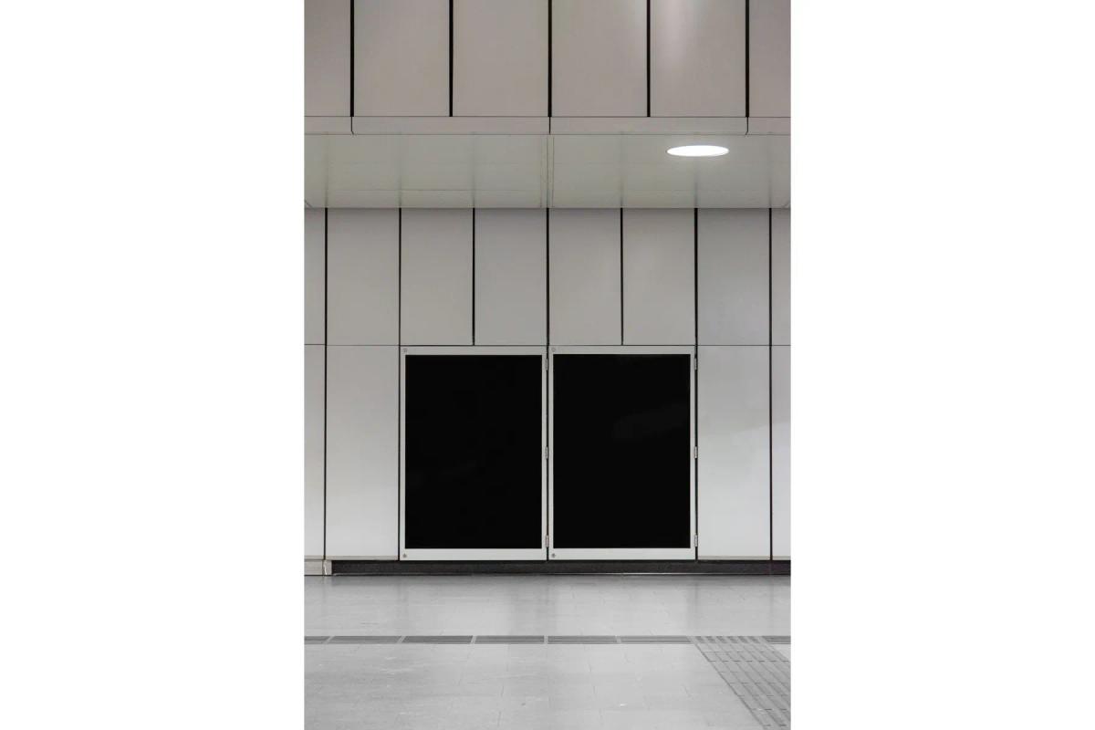 Two blank poster mockups displayed in a subway station, set against a white tiled wall, ready for the addition of transit advertising or public notices.