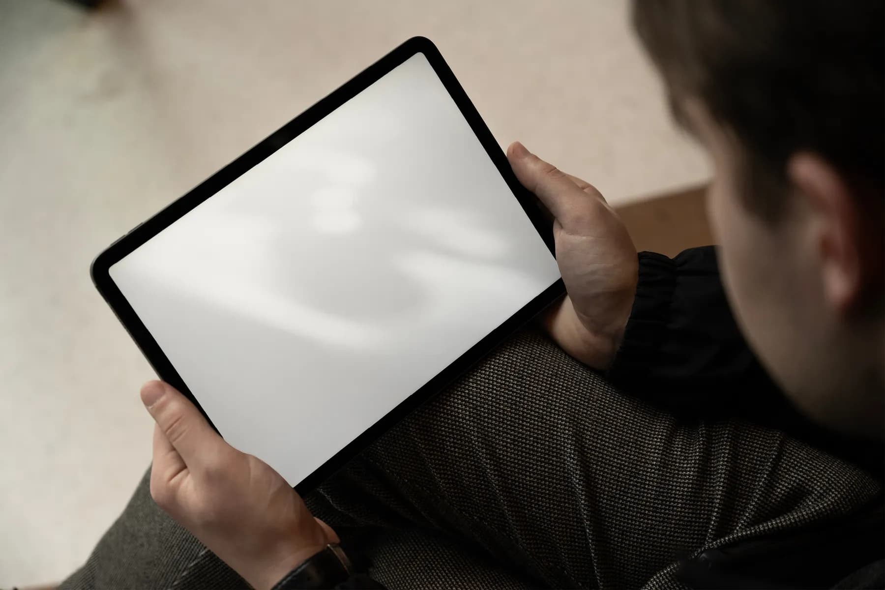 Tablet screen mockup showing a blank screen, held by a person, ready for content customization and branding presentation.