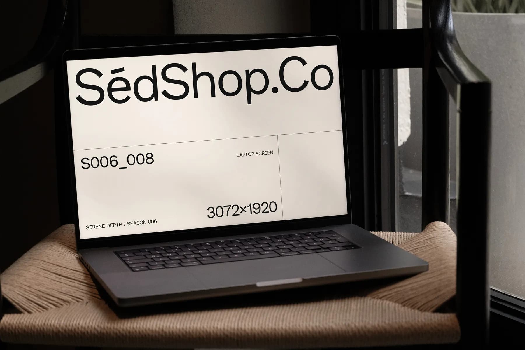 Laptop screen mockup with text and resolution details displayed on a bright screen, set on a chair in a dimly lit room.
