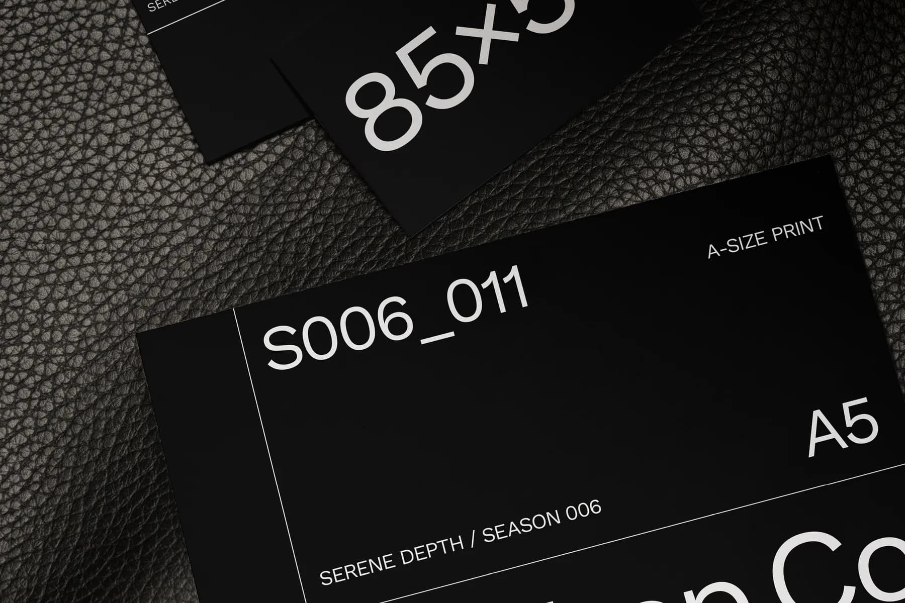 Detailed mockup of business cards and an A5 print card with text and design elements, shown on a textured dark background.