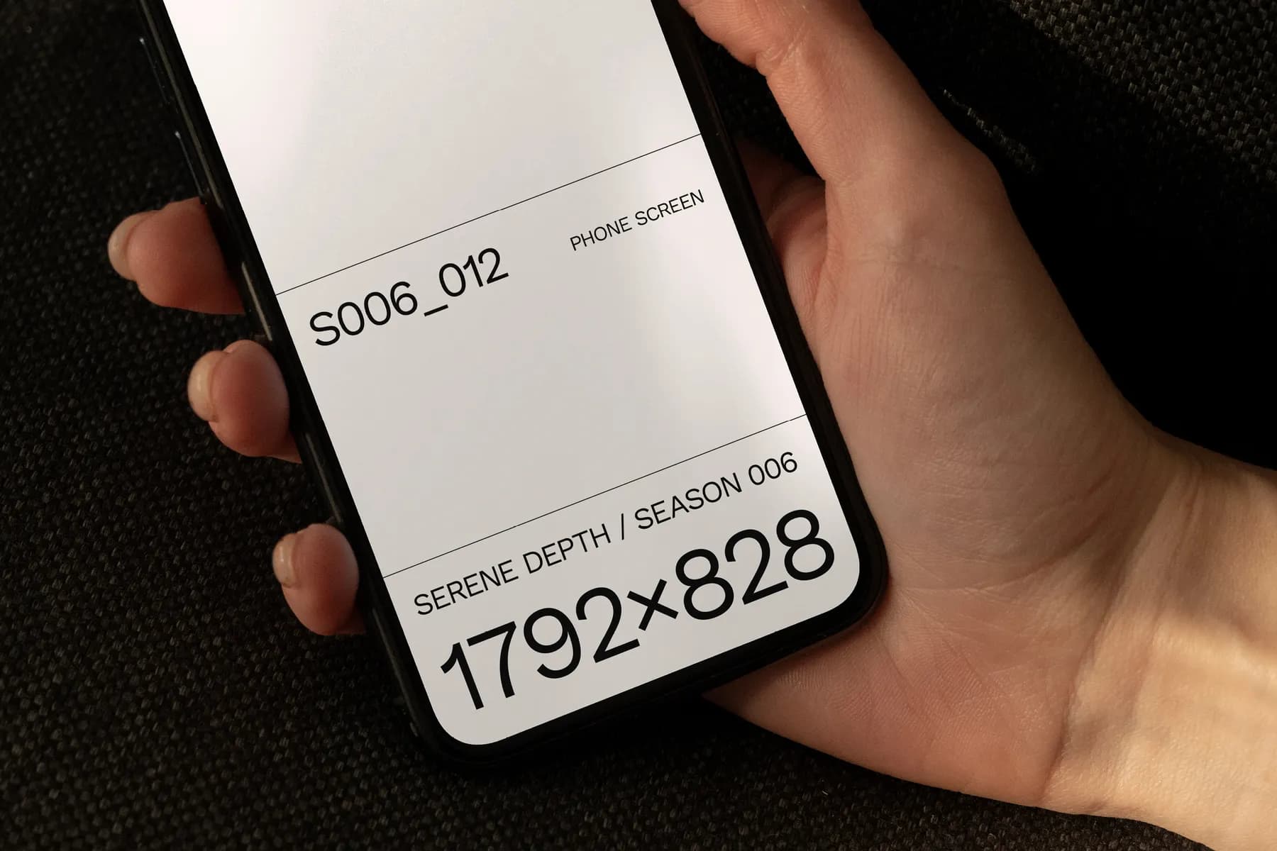 Phone screen mockup showing a bright screen with text and resolution details, held by a hand on a dark background.