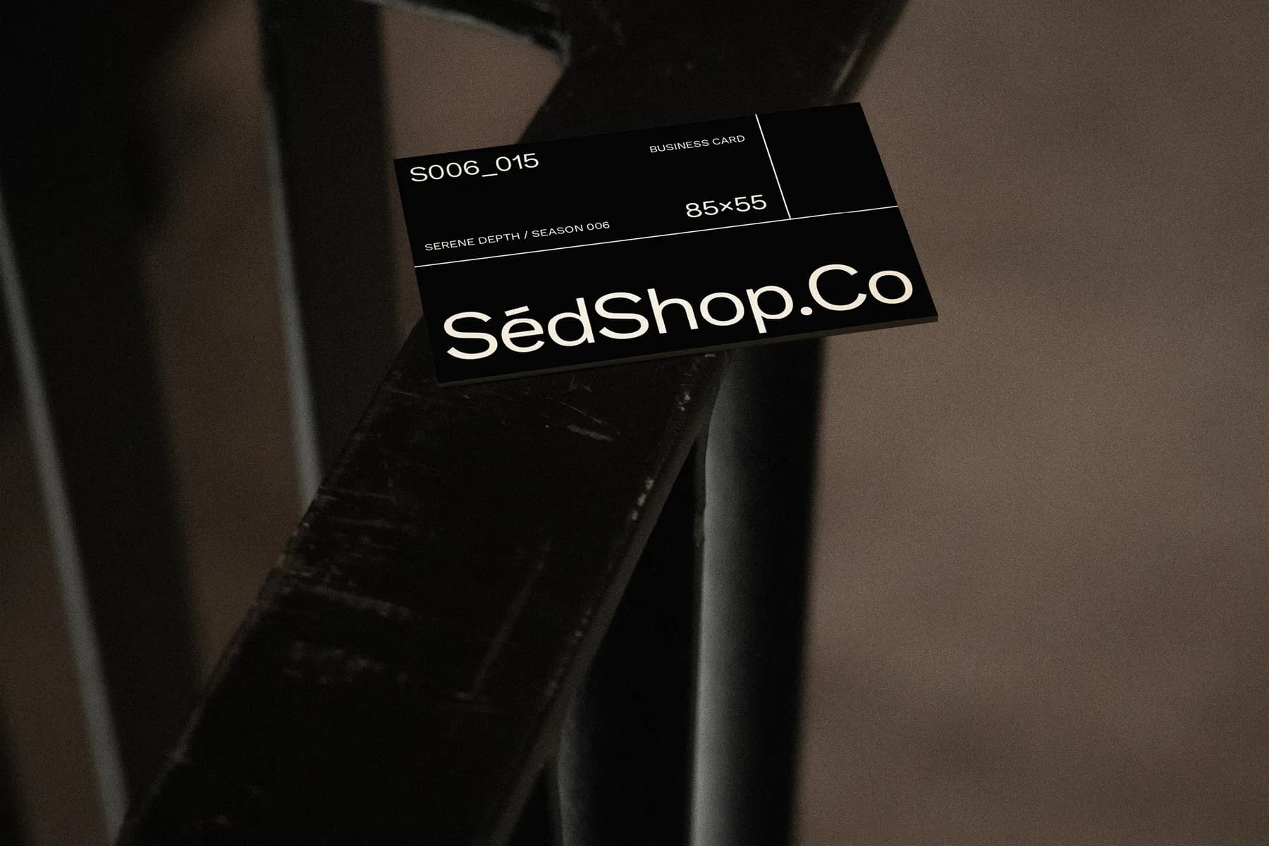 Close-up of business card mockup on dark metal, showing design details with S006_015 code and dimensions 85x55.