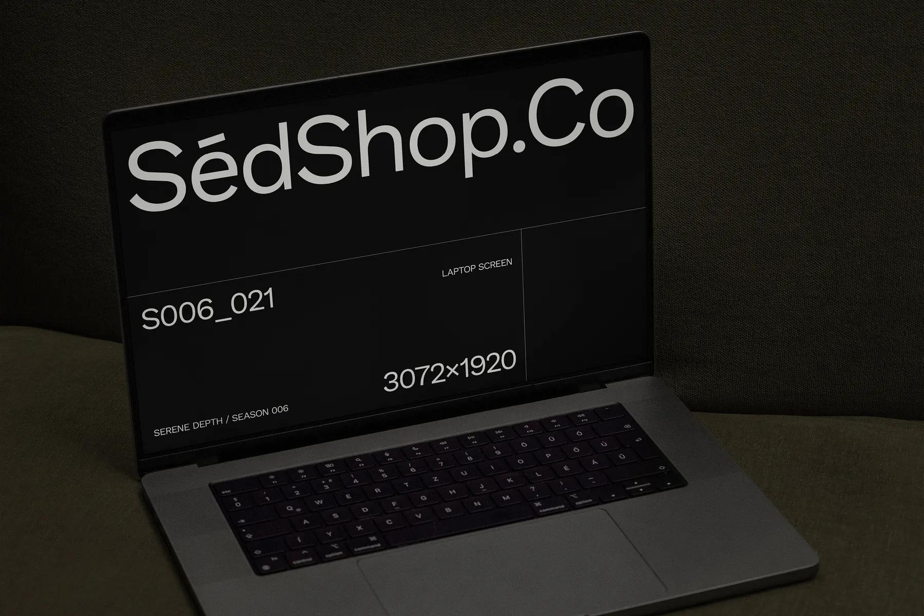 Close-up mockup of a laptop screen on a green couch, displaying SédShop.Co branding with a dark-themed minimalist design.