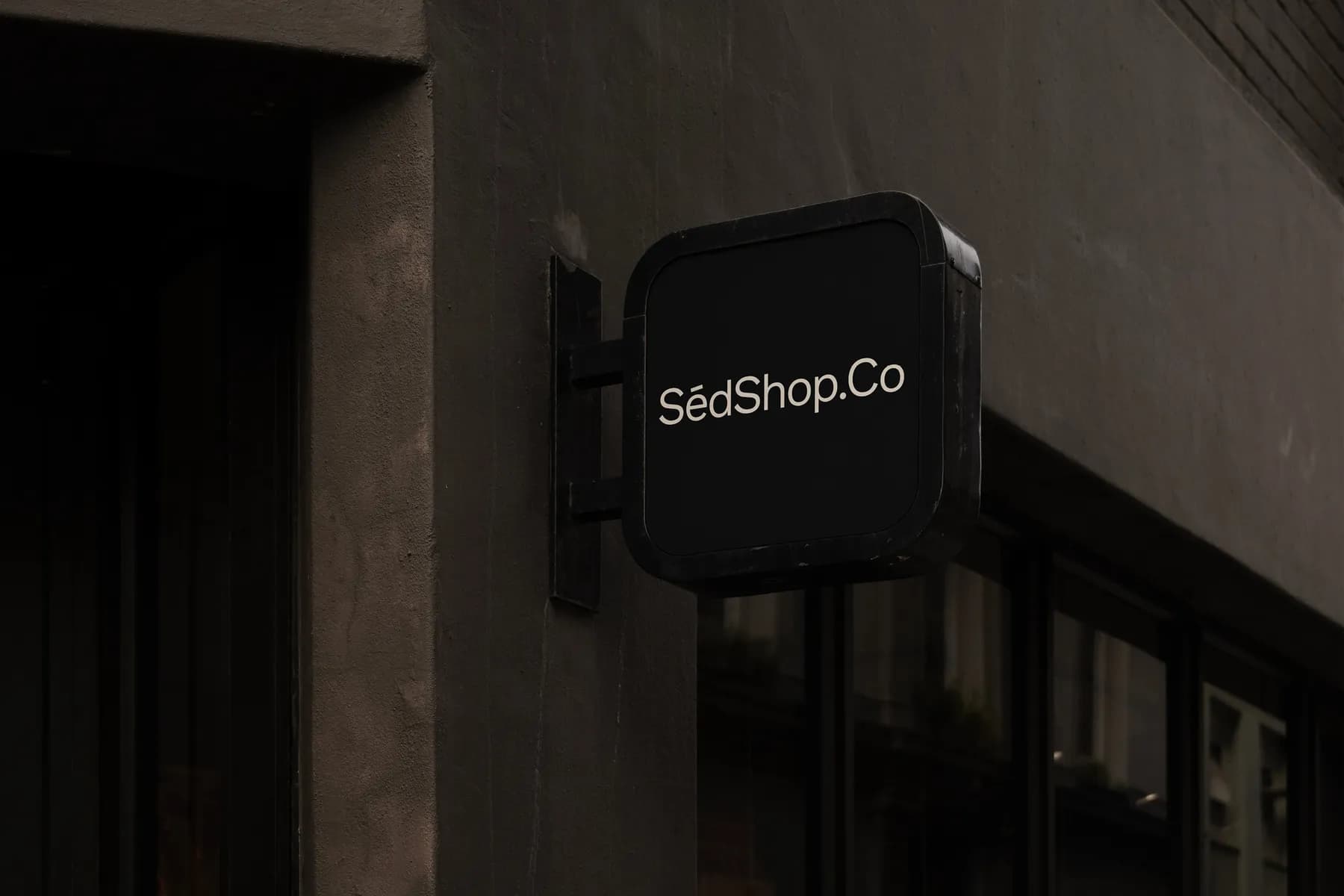 Sign mockup with 'SédShop.Co' text on a dark building facade, emphasizing customizable design and high realism
