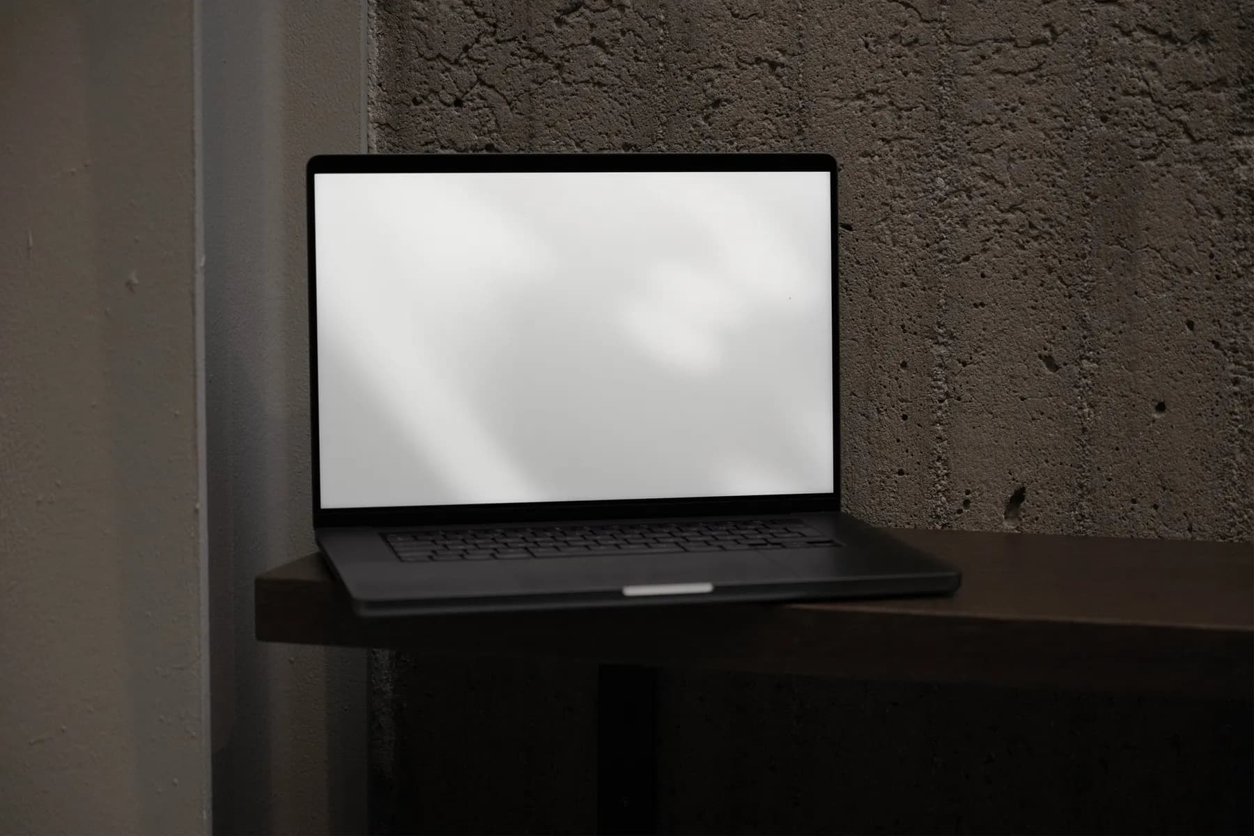 Blank laptop screen mockup on a wooden shelf, ready for design customization, with a realistic, textured background setting.