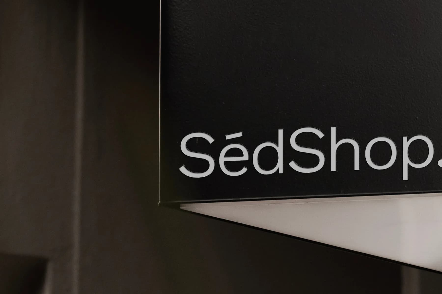 Detailed view of a cut-out sign mockup on a building facade, featuring 'SédShop.Co' text, highlighting customizable design elements.
