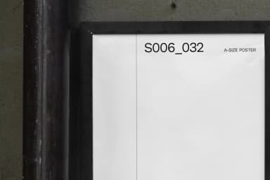 Detailed view of a blank A2 poster mockup on an exterior wall, framed in black and ready for customization.